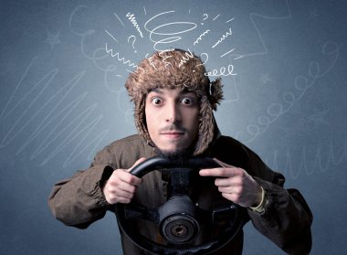 Holding siyah direksiyon simidi etrafındaki beyaz karalamalar ile genç adam