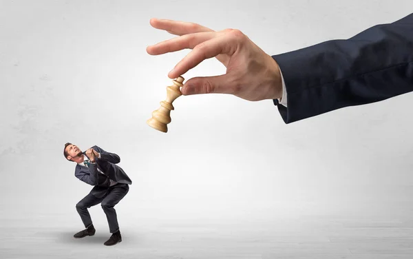 Big hand with chessman down small weak businessman concept — Stock Photo, Image
