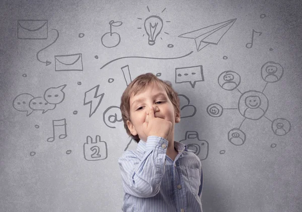 Niño inteligente frente a una pared gris dibujada —  Fotos de Stock