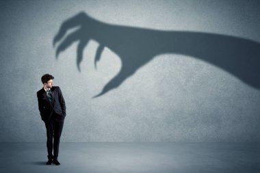 İş kişi büyük canavar pençe gölge kavramı korkuyor