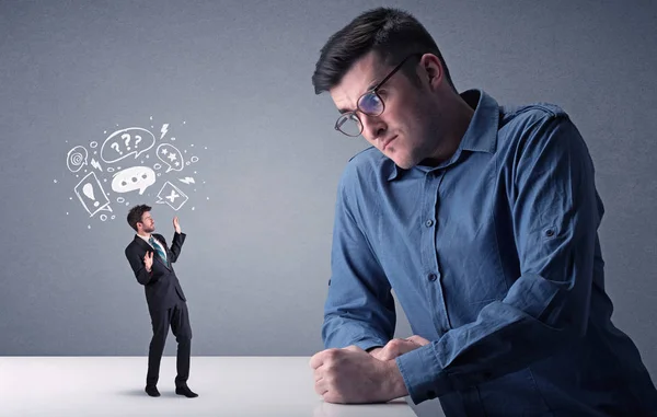 Young businessman fighting with miniature businessman — Stock Photo, Image