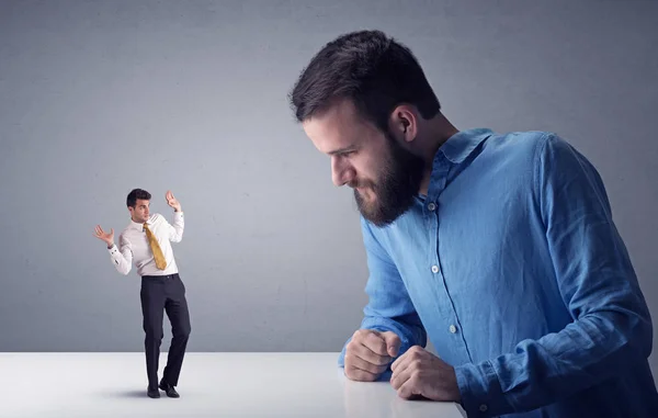 Joven hombre de negocios luchando con empresario en miniatura —  Fotos de Stock