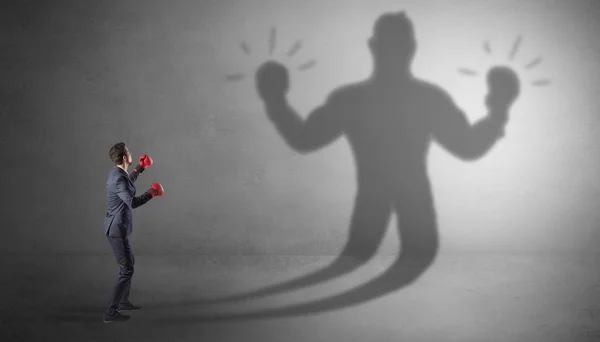 Businessman fighting with his unarmed shadow — Stock Photo, Image