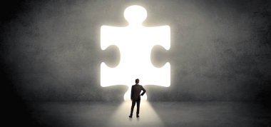 Bir büyük bulmaca parçası önünde duran işadamı