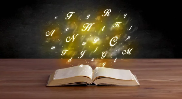 Алфавитные буквы над книгой — стоковое фото