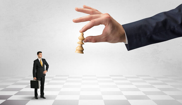 Бизнесмен борется с большим шахматистом на большой руке
