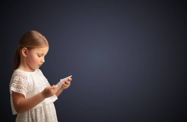 Tablet ile koyu arka plan kullanarak sevimli küçük kız