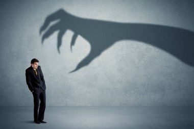 İş kişi büyük canavar pençe gölge kavramı korkuyor