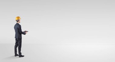 Boş bir alanda duran ve bir plan tutan mimar