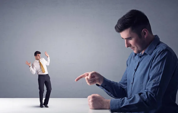 Joven hombre de negocios luchando con empresario en miniatura — Foto de Stock