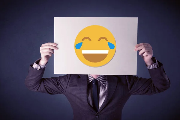 Uomo d'affari in possesso di carta con emoticon ridere — Foto Stock