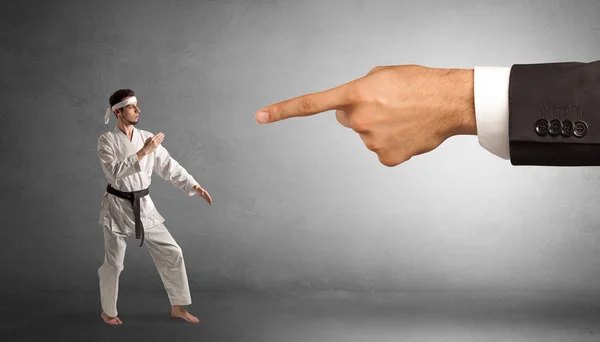 Gran mano la captura de hombre pequeño karate — Foto de Stock