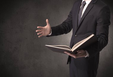 Elinde kitap tutan bir işadamı.