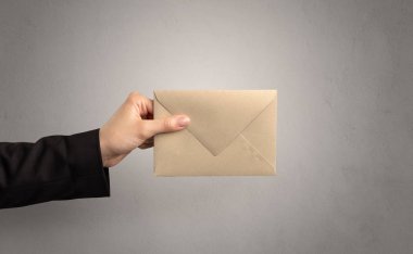 Zarf boş duvar arka plan ile tutan el