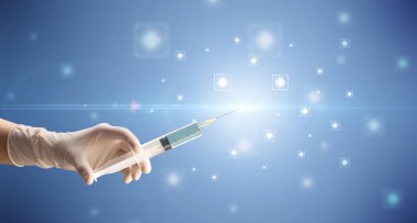 Kadın doktor elinde şırınga tutuyor.