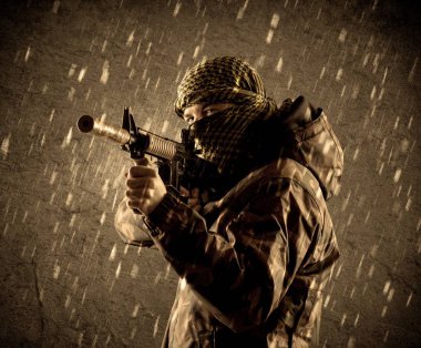 Tehlikeli ağır silahlı terörist asker maskesi grungy yağmurlu zemin üzerine 