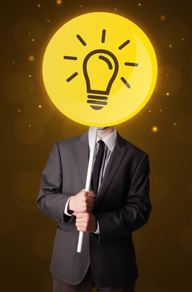 Businessman holding lightbulb sign — Stock Photo, Image