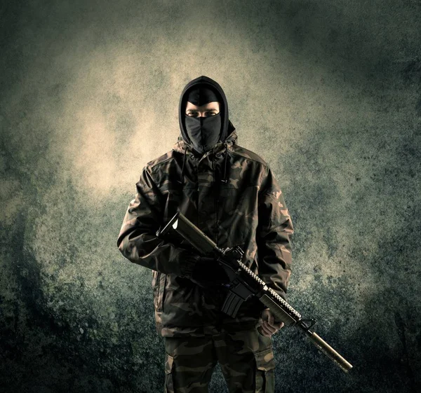 Porträt eines schwer bewaffneten, maskierten Soldaten mit grundigem Hintergrund — Stockfoto