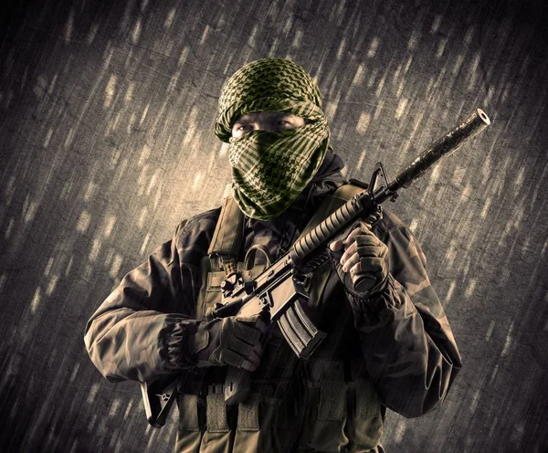 Yağmurlu arka plan üzerinde Maskeli silahlı terörist adam