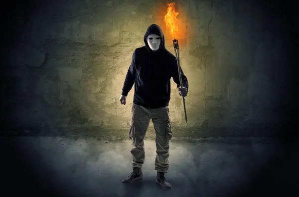 Wayfarer with burning torch in front of crumbly wall concept — Stock Photo, Image