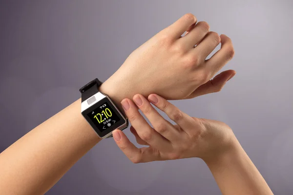 Female hand wearing and pressing smartwatch — Stock Photo, Image