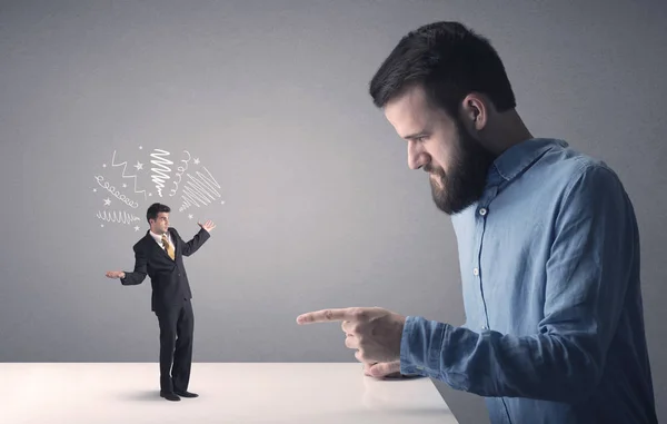 Young businessman fighting with miniature businessman — Stock Photo, Image