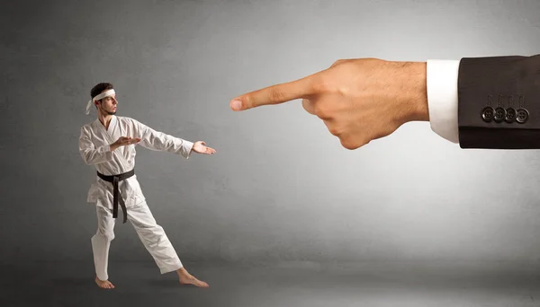 Gran mano la captura de hombre pequeño karate — Foto de Stock
