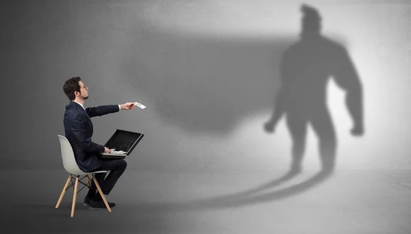 Бізнесмен залишається і пропонує речі в супергеройську тінь — стокове фото
