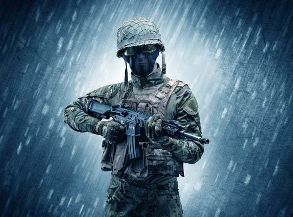 Вооруженный солдат, стоящий в дождливую погоду — стоковое фото