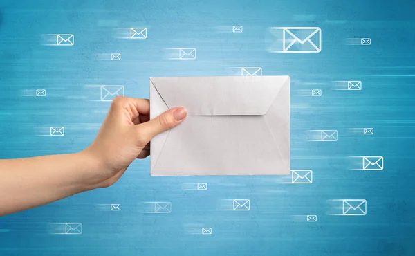 Hand holding envelope with message symbols around — Stock Photo, Image