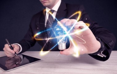 renkli bir ampul tutan işadamı