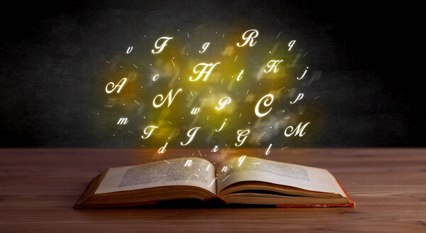Glowing yellow alphabet letters coming out of an open book