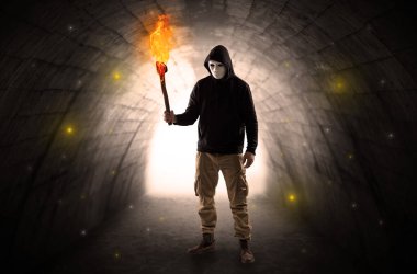 Karanlık bir tünelde flambeau yanma ile yürüyen adam
