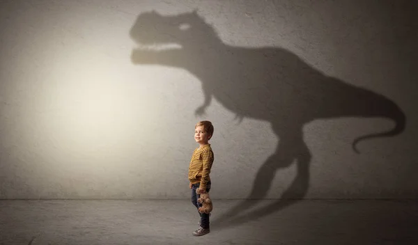 Dinosaurus skygger bak en søt gutt – stockfoto
