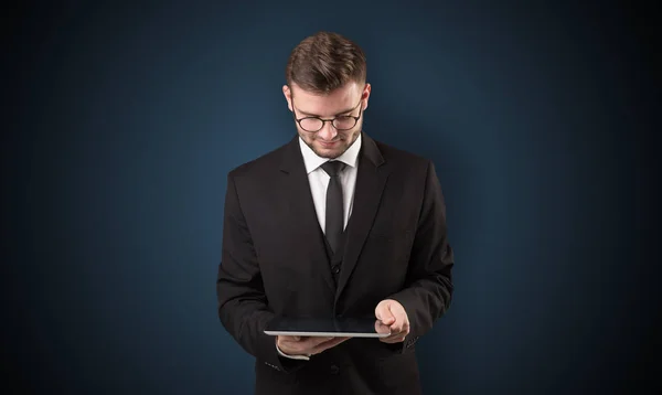 Empresario sosteniendo tableta con fondo oscuro — Foto de Stock