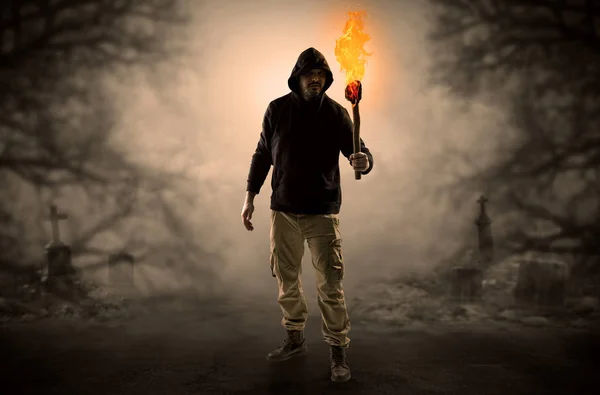 Man coming out from a thicket with burning flambeau — Stock Photo, Image