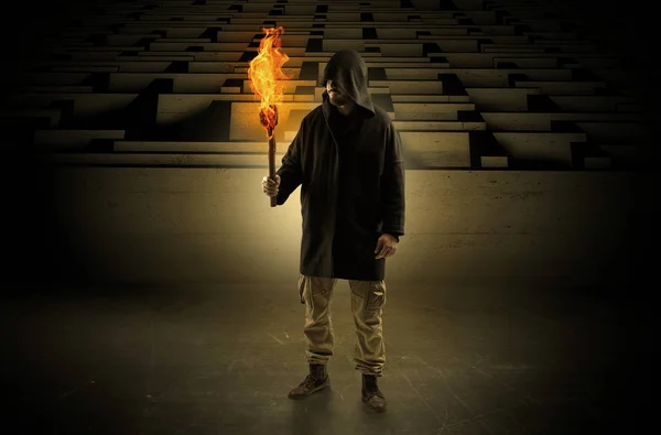 Man coming with burning flambeau from the maze concept