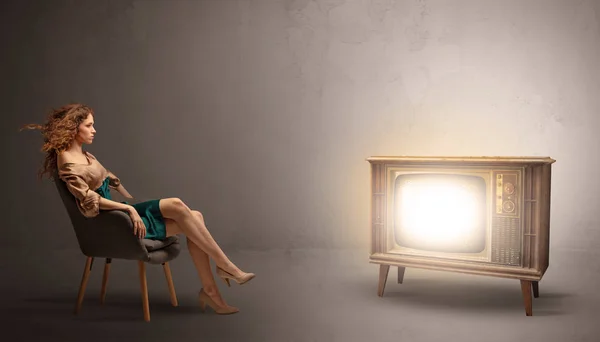 Young lady watching to a vintage television — Stock Photo, Image