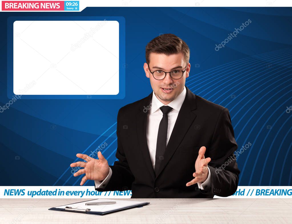 Television reporter telling breaking news at his studio desk with copy space 