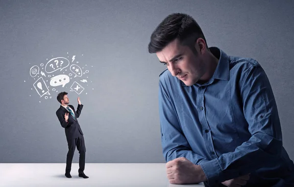 Young businessman fighting with miniature businessman — Stock Photo, Image