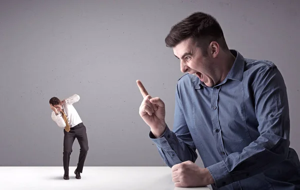 Joven hombre de negocios luchando con empresario en miniatura —  Fotos de Stock