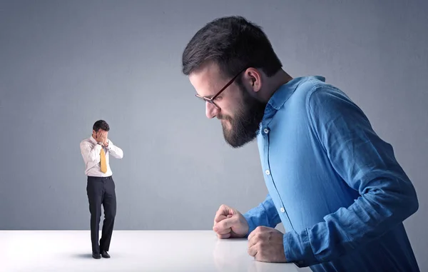 Joven hombre de negocios luchando con empresario en miniatura —  Fotos de Stock