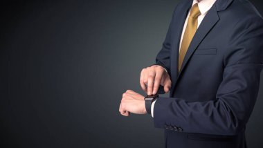 Smartwatch giyen takım elbiseli adam.