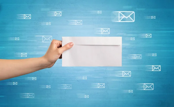 Hand hält Umschlag mit Botschaftssymbolen herum — Stockfoto