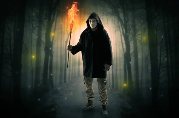 Mann kommt aus dunklem Wald mit brennendem Flambeau in der Hand — Stockfoto