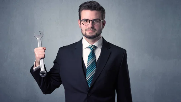 Young Handsome Cute Businessman Holding Tool Grey Background — Stock Photo, Image