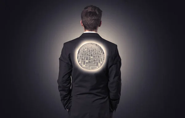 Businessman standing with maze on his back — Stock Photo, Image