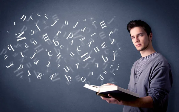 Jovem segurando livro com letras — Fotografia de Stock