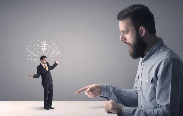 Young businessman fighting with miniature businessman — Stock Photo, Image