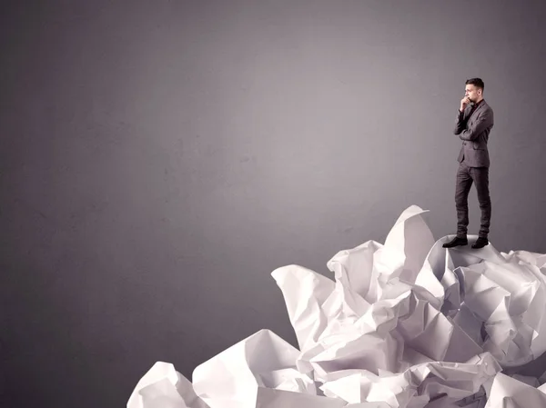 Businessman standing on crumpled paper — Stock Photo, Image